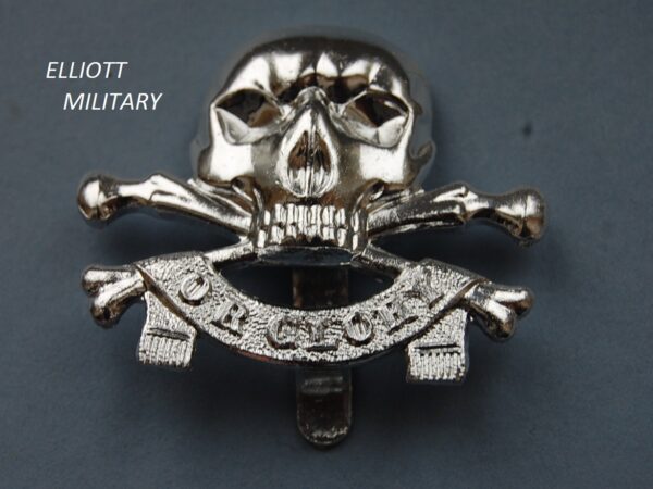 badge with scull and crossed bones above a banner reading or glory