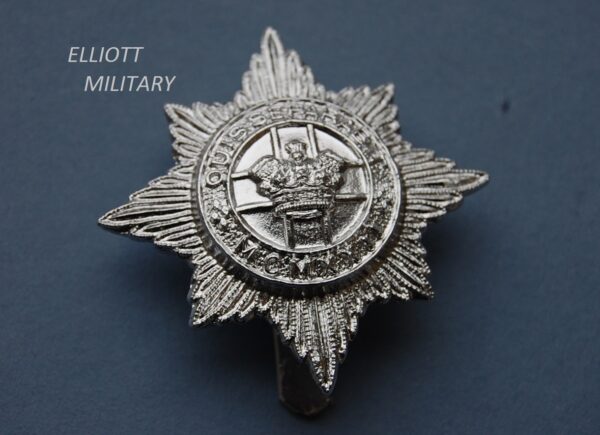 badge with crown in front of a cross within a circle in front of an 8 pointed star