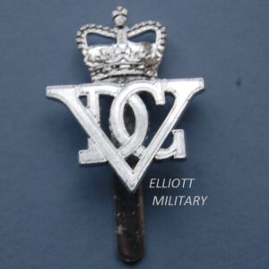 badge with Roman numeral V and letters D G underneath a crown