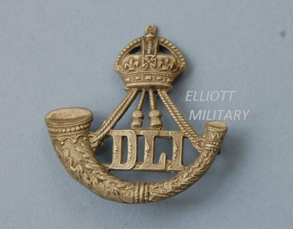 badge with a crown above a strung bugle and letters DLI