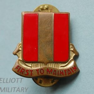 badge with red and gold striped shield and scroll underneath reading First to maintain