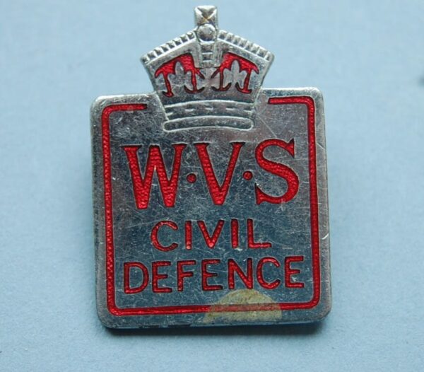 small pin badge with crown above the letters WVA CIVIL DEFENCE in red ename